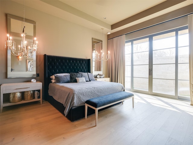 bedroom with a chandelier, hardwood / wood-style floors, and access to exterior