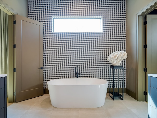 bathroom featuring tile patterned flooring, vanity, and a bath