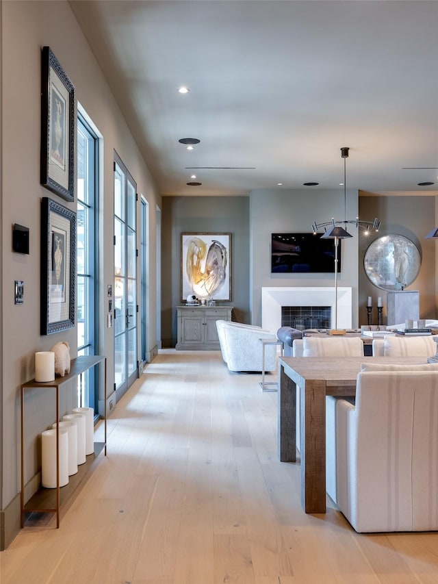 interior space with a fireplace, light hardwood / wood-style flooring, and hanging light fixtures