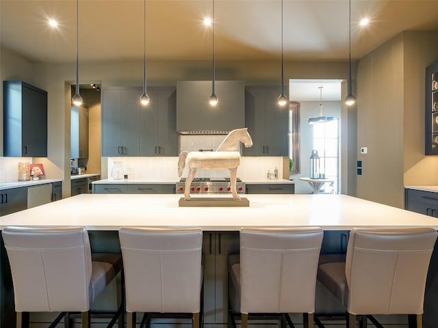 kitchen with a kitchen breakfast bar, a center island with sink, and decorative light fixtures