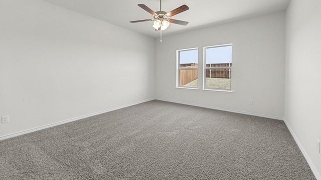 carpeted empty room featuring baseboards and ceiling fan