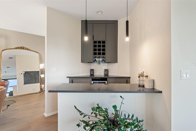 bar featuring pendant lighting, light wood-type flooring, tasteful backsplash, and gray cabinets