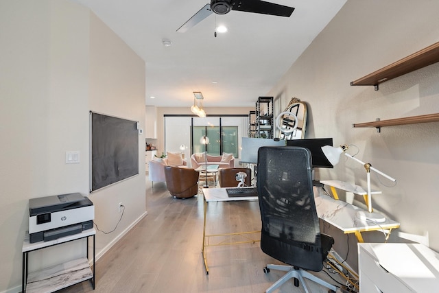 office with light wood-type flooring and ceiling fan