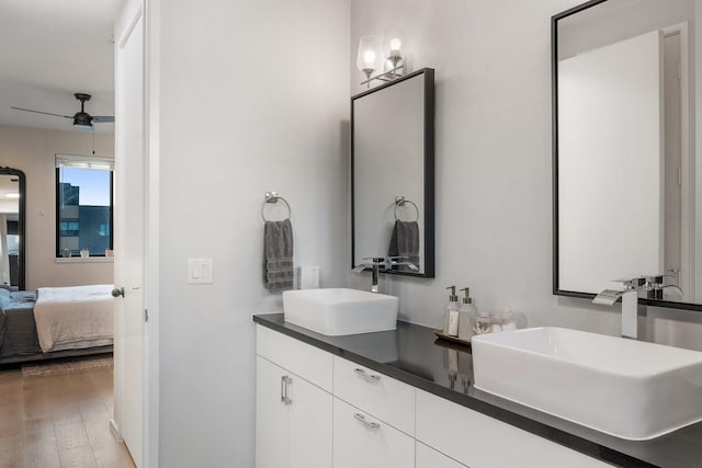 bathroom with hardwood / wood-style floors, vanity, and ceiling fan