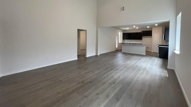 4237 Zayan Dr, Sherman, TX 75090 - unfurnished living room with a high ceiling, baseboards, wood finished floors, and recessed lighting