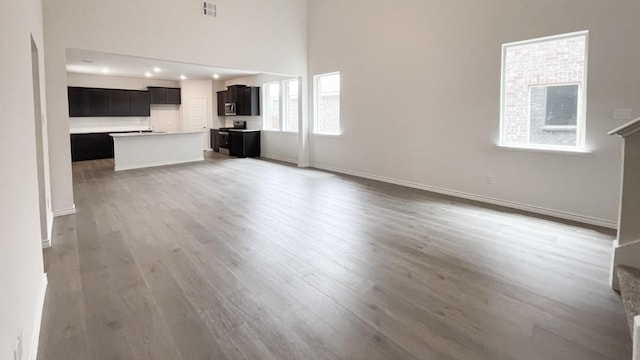 4237 Zayan Dr, Sherman, TX 75090 - unfurnished living room with light wood finished floors, baseboards, recessed lighting, and a high ceiling