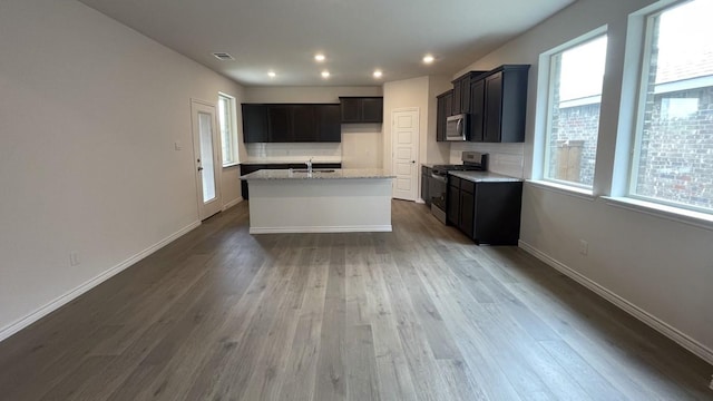 4237 Zayan Dr, Sherman, TX 75090 - kitchen with stainless steel appliances, a sink, wood finished floors, a kitchen island with sink, and baseboards