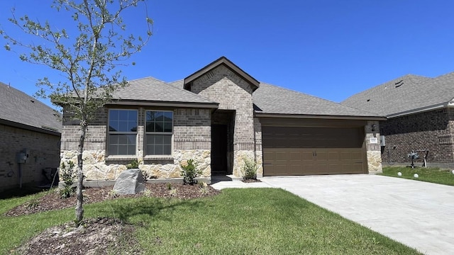 4208 Lucy Ln, Sherman, TX 75090 - view of front facade featuring a garage, driveway, stone siding, a front yard, and a shingled roof