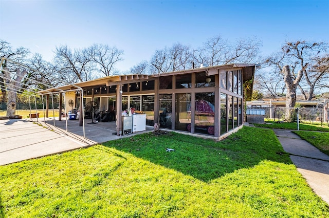 rear view of house featuring a yard and a patio