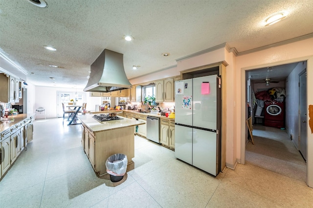 kitchen featuring appliances with stainless steel finishes, ornamental molding, island range hood, washer and dryer, and a center island