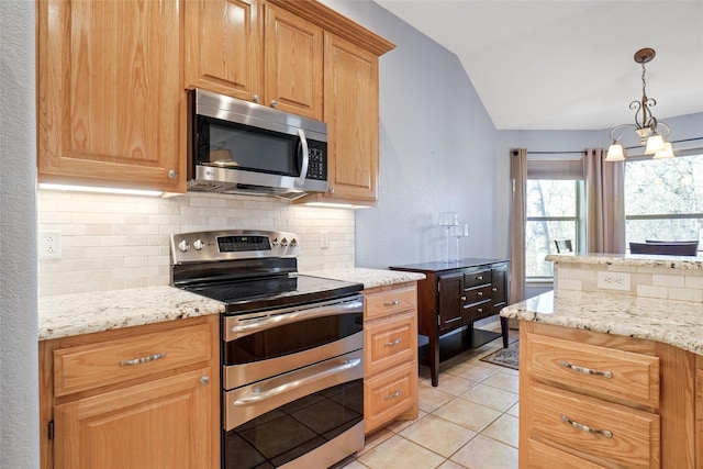 kitchen featuring light stone countertops, a notable chandelier, backsplash, appliances with stainless steel finishes, and light tile patterned flooring