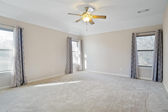 empty room with vaulted ceiling, light colored carpet, and ceiling fan