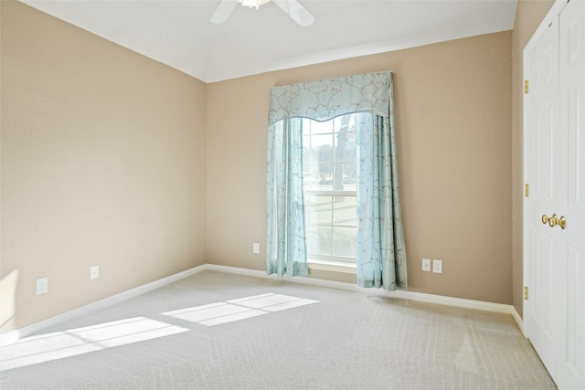 carpeted spare room featuring ceiling fan and a healthy amount of sunlight