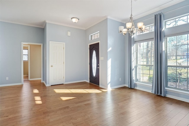 foyer with a notable chandelier, crown molding, and hardwood / wood-style flooring