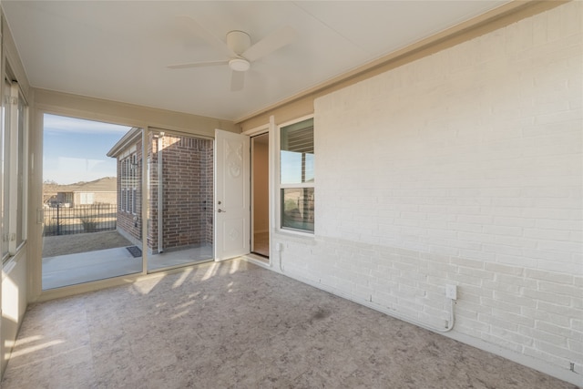 exterior space featuring brick wall, carpet flooring, and ceiling fan