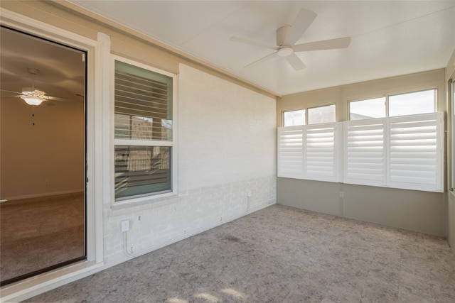 unfurnished sunroom featuring ceiling fan