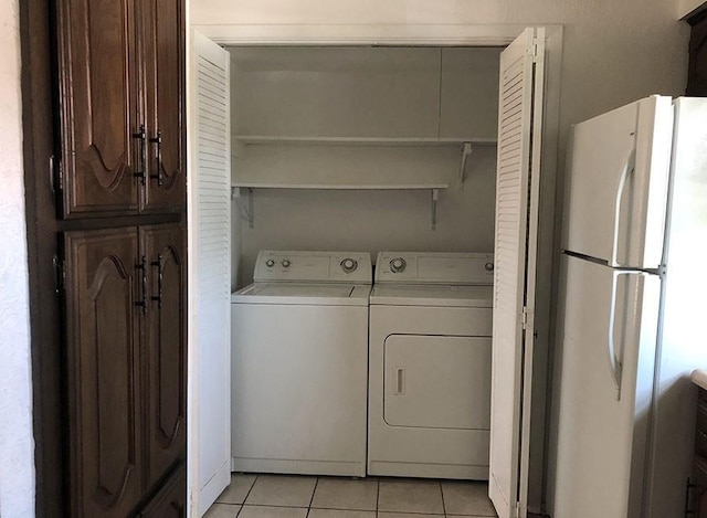 laundry area with light tile patterned flooring and washer and dryer