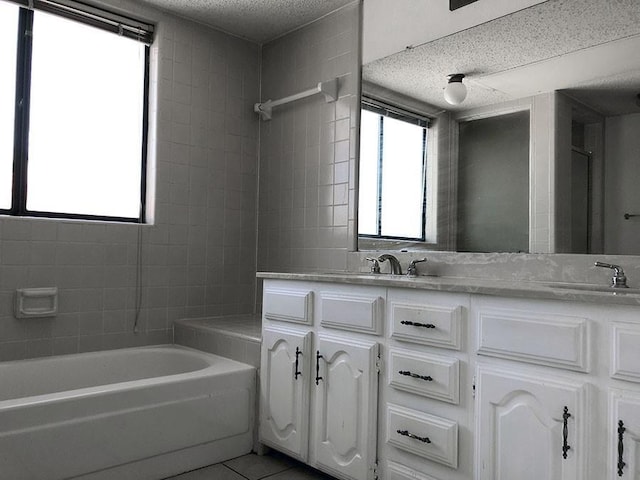 bathroom featuring a textured ceiling, vanity, and tile patterned floors