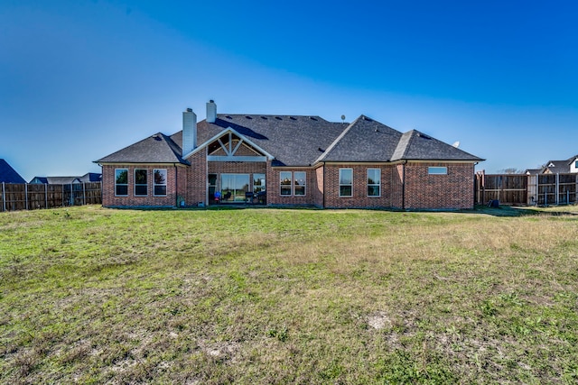 rear view of house featuring a yard