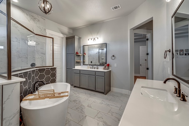 bathroom featuring a tub, vanity, tile walls, and a notable chandelier