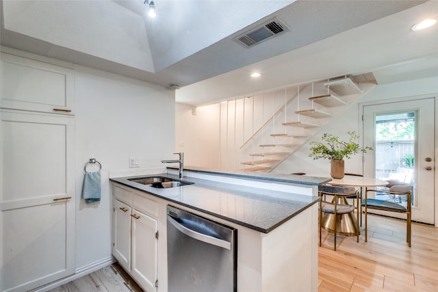 kitchen featuring sink, light hardwood / wood-style flooring, stainless steel dishwasher, and white cabinets