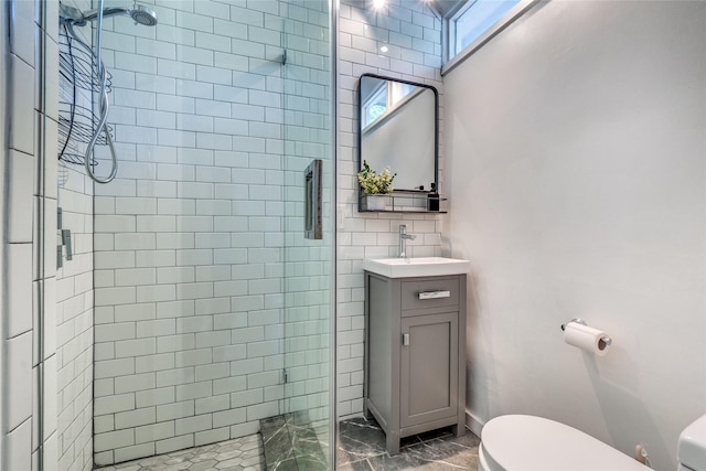 bathroom with walk in shower, vanity, and toilet