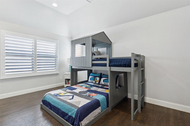 bedroom with dark wood-type flooring and lofted ceiling