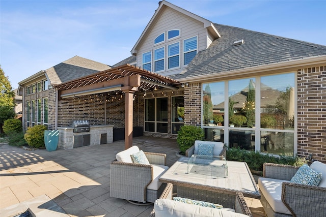 back of property featuring an outdoor kitchen, a pergola, and a patio