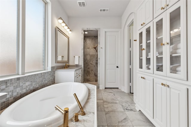 bathroom featuring plus walk in shower and vanity