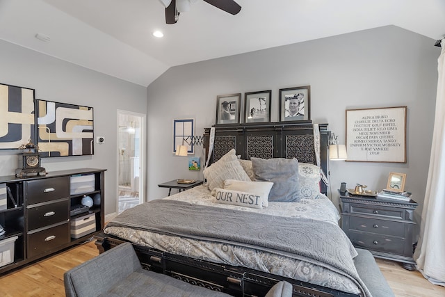 bedroom with light wood-type flooring, ensuite bathroom, vaulted ceiling, and ceiling fan