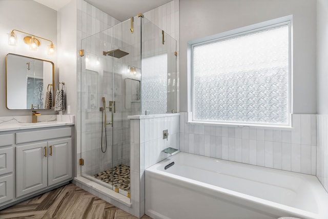 bathroom featuring vanity, parquet floors, and shower with separate bathtub