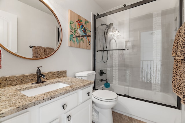 full bathroom featuring vanity, toilet, and shower / bath combination with glass door