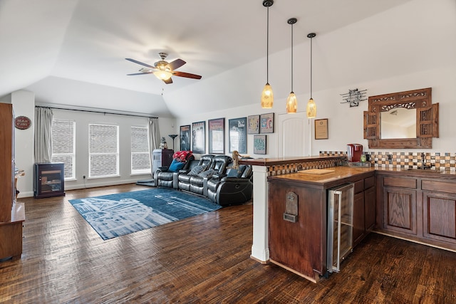 kitchen featuring tasteful backsplash, kitchen peninsula, beverage cooler, and lofted ceiling