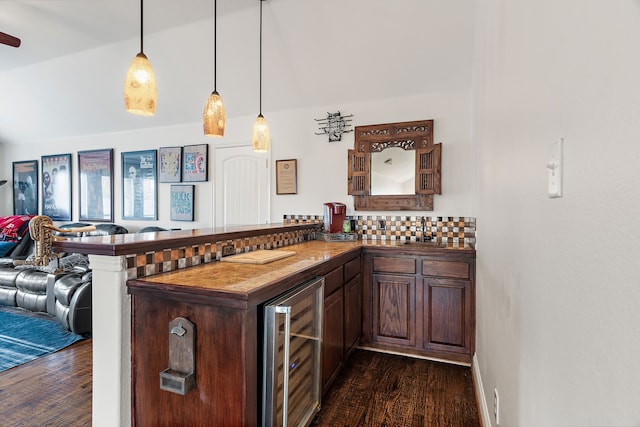 bar with decorative backsplash, dark hardwood / wood-style flooring, dark brown cabinets, beverage cooler, and decorative light fixtures