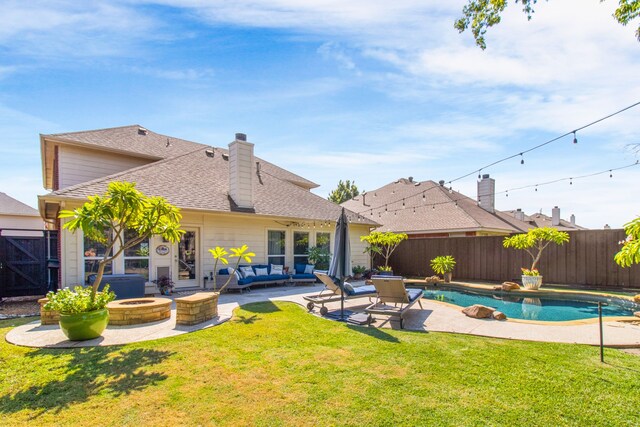 back of house featuring a patio area, a yard, a fenced in pool, and an outdoor living space with a fire pit