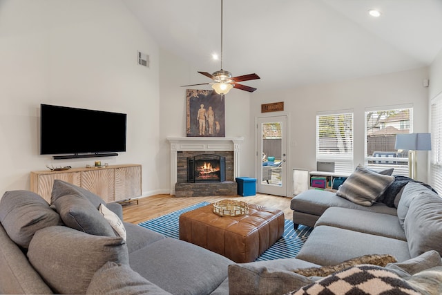 living room featuring ceiling fan, wood-type flooring, a fireplace, and high vaulted ceiling