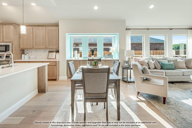 dining room with sink, a wealth of natural light, and light hardwood / wood-style flooring