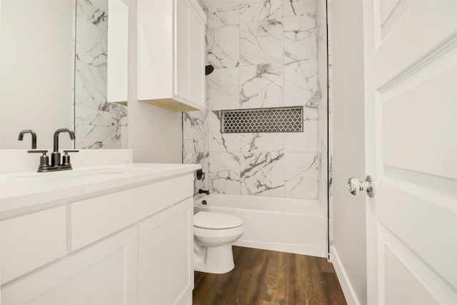 full bathroom featuring tiled shower / bath combo, toilet, wood-type flooring, and vanity