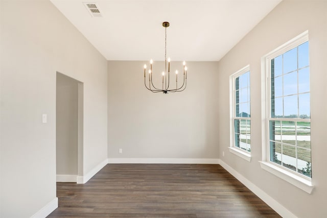 unfurnished dining area featuring a chandelier and dark hardwood / wood-style flooring