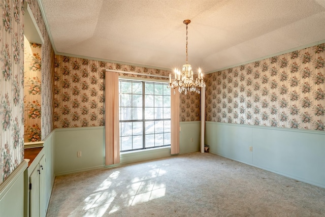 unfurnished dining area featuring light carpet, a textured ceiling, an inviting chandelier, and crown molding