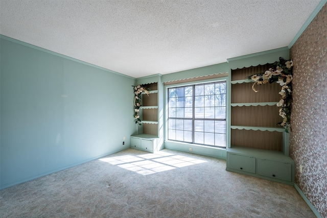 unfurnished room with crown molding, light colored carpet, and a textured ceiling