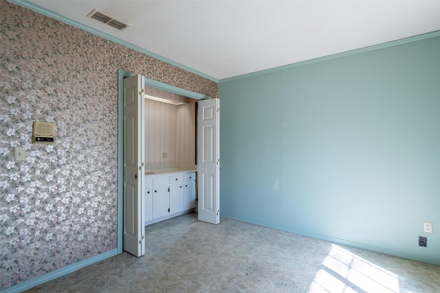 unfurnished bedroom featuring crown molding and light carpet