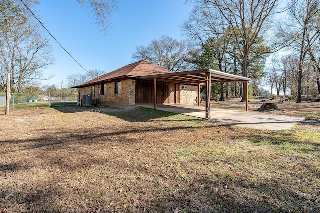 view of property exterior featuring a lawn, central AC, and a carport