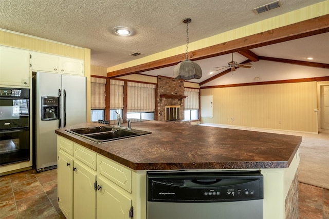 kitchen featuring appliances with stainless steel finishes, a textured ceiling, ceiling fan, sink, and a center island with sink