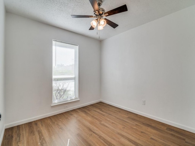 empty room featuring a wealth of natural light, ceiling fan, light hardwood / wood-style floors, and a textured ceiling