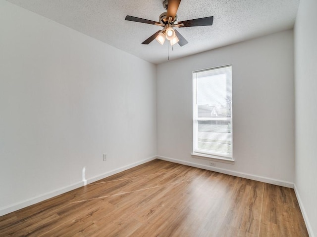 empty room with ceiling fan, light hardwood / wood-style flooring, a healthy amount of sunlight, and a textured ceiling