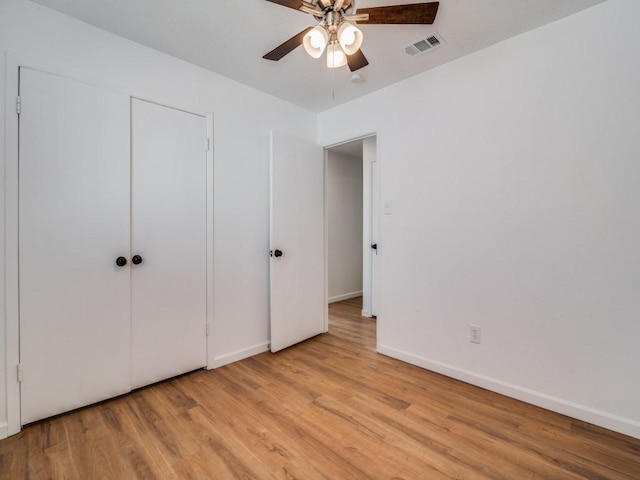 unfurnished bedroom with ceiling fan, a closet, and light hardwood / wood-style floors