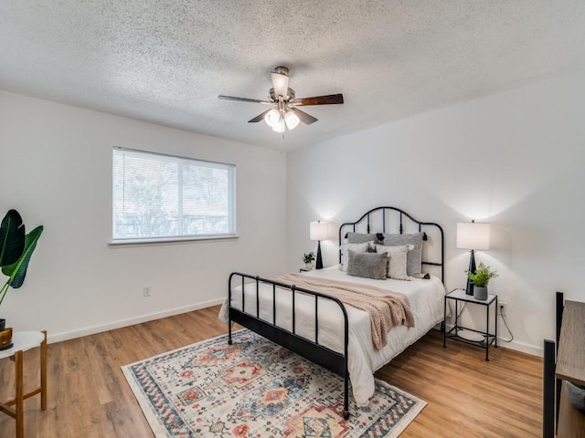 bedroom featuring hardwood / wood-style flooring, ceiling fan, and a textured ceiling