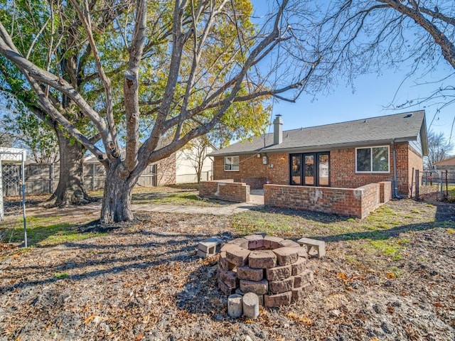 back of house featuring an outdoor fire pit