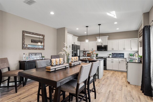 dining area featuring sink and light hardwood / wood-style floors